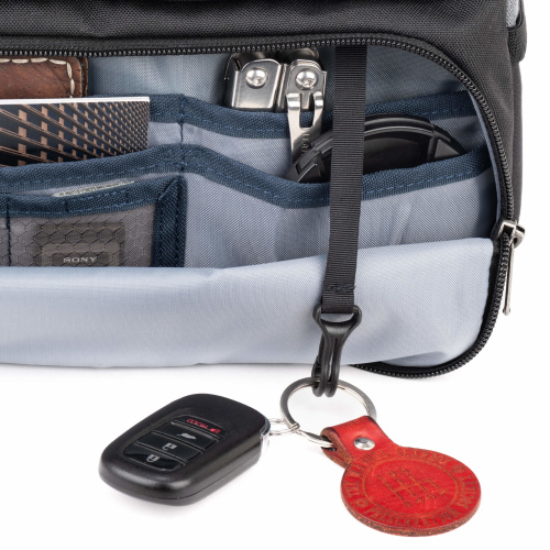 Eine Detailaufnahme des geöffneten vorderen Organizer-Fachs einer schwarzen Think Tank Mirrorless Mover Kameratasche, freigestellt auf weißem Hintergrund. Das hellgrau gefütterte Innenfach zeigt verschiedene elastische Netztaschen und Einschübe, in denen